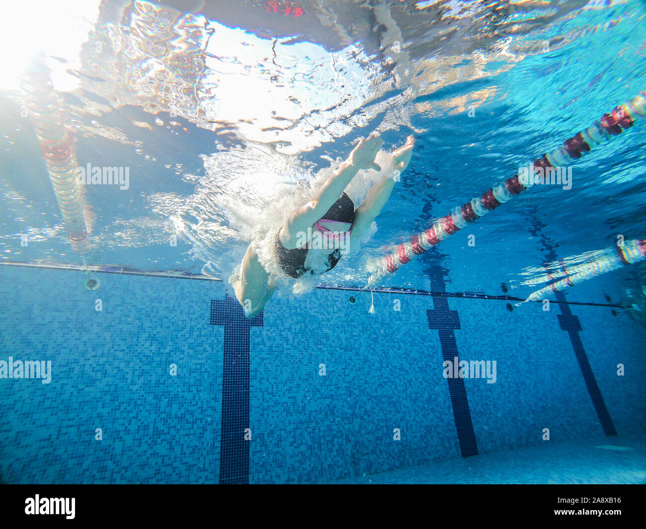 Mujer saltando en la piscina pública de actividades deportivas Foto de stock