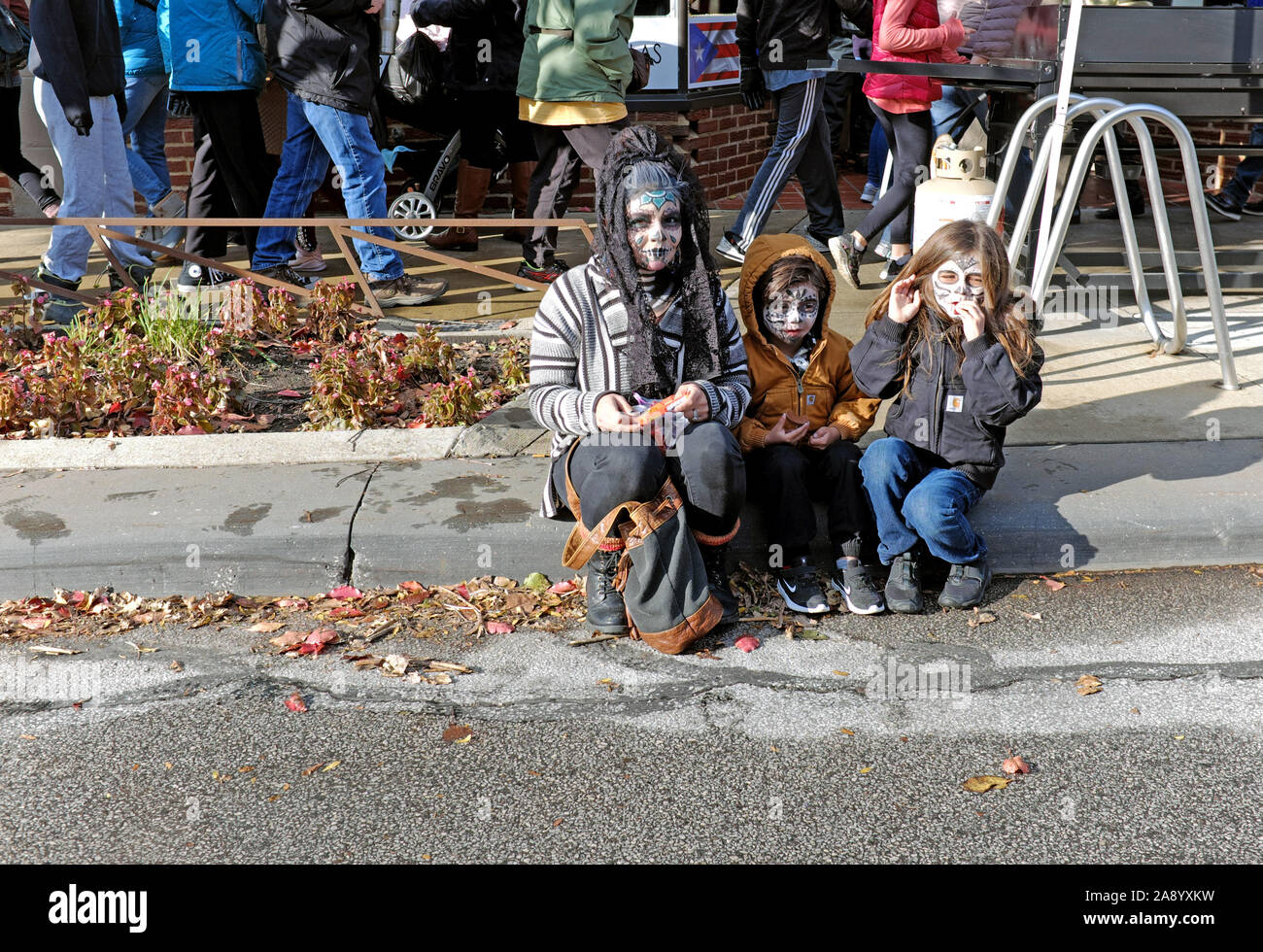 Tres jóvenes espectadores participan en la celebración del Día de los Muertos en el barrio de Gordon Square en Cleveland, Ohio, el 2 de noviembre de 2019. Foto de stock