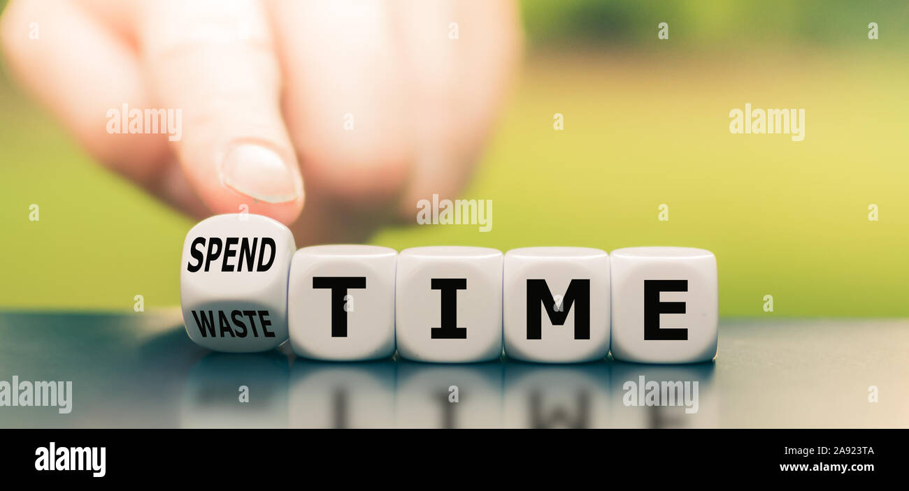 Convierte un dedo dados y cambia la expresión "pérdida de tiempo" para "gastar tiempo'. Foto de stock