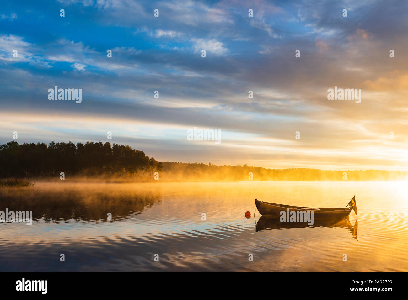 Barco en el lago al amanecer. Foto de stock