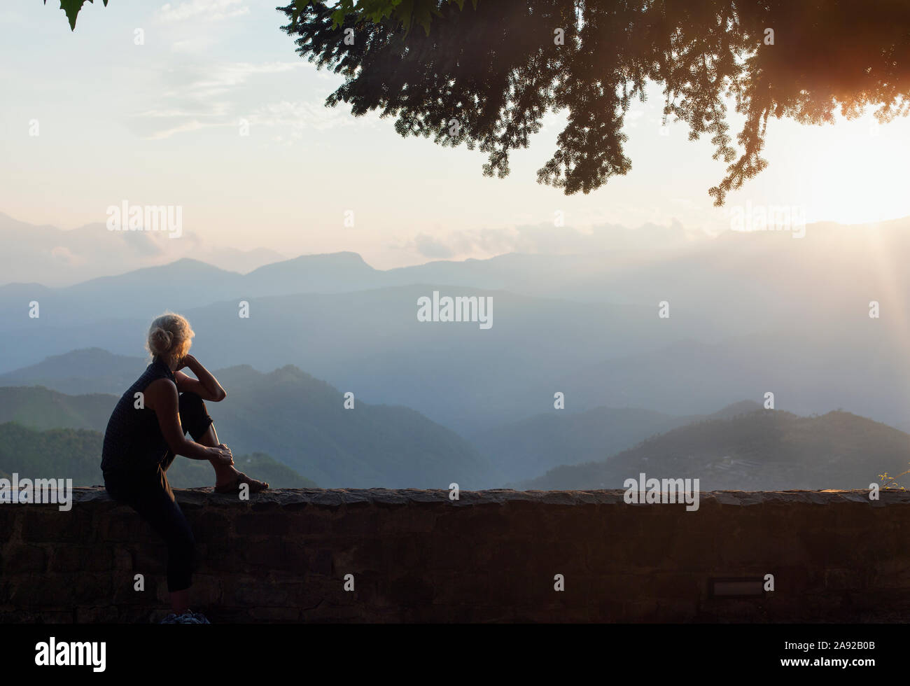 Mujer sentada y mirando las montañas Foto de stock
