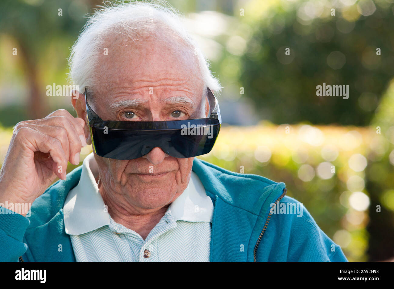 Retrato de un hombre mayor con gafas oscuras de cataratas