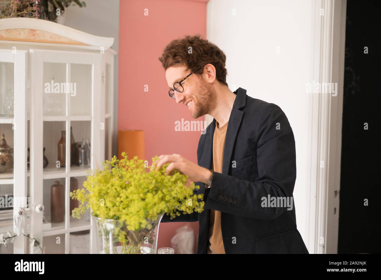 Hombre sonriendo mirando las flores Foto de stock