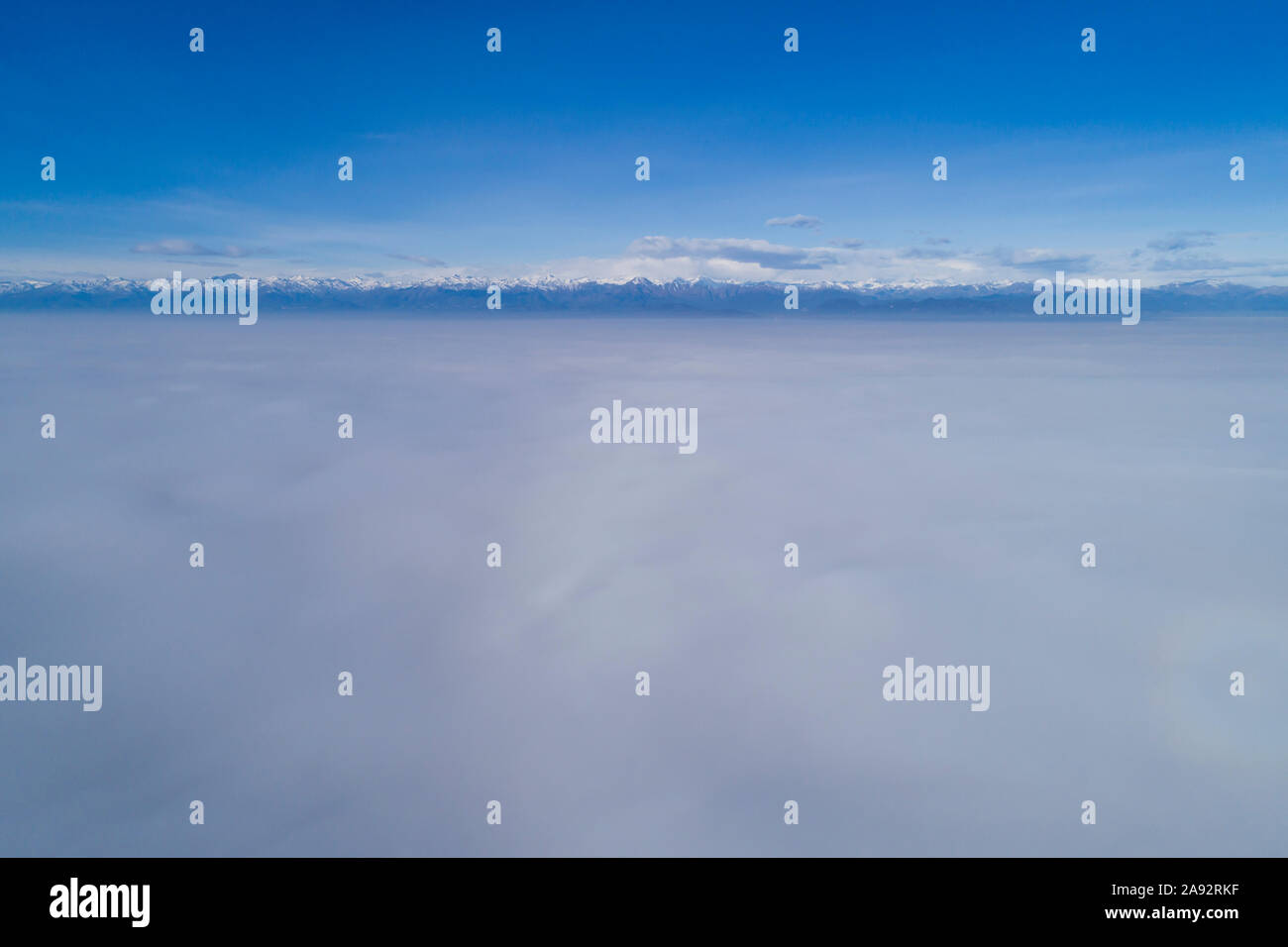 Vista aérea, volando por encima de las nubes de niebla. Vista panorámica del valle del Po (Italia) cubierto por una espesa niebla con los Alpes y el Monte Rosa grupo Foto de stock