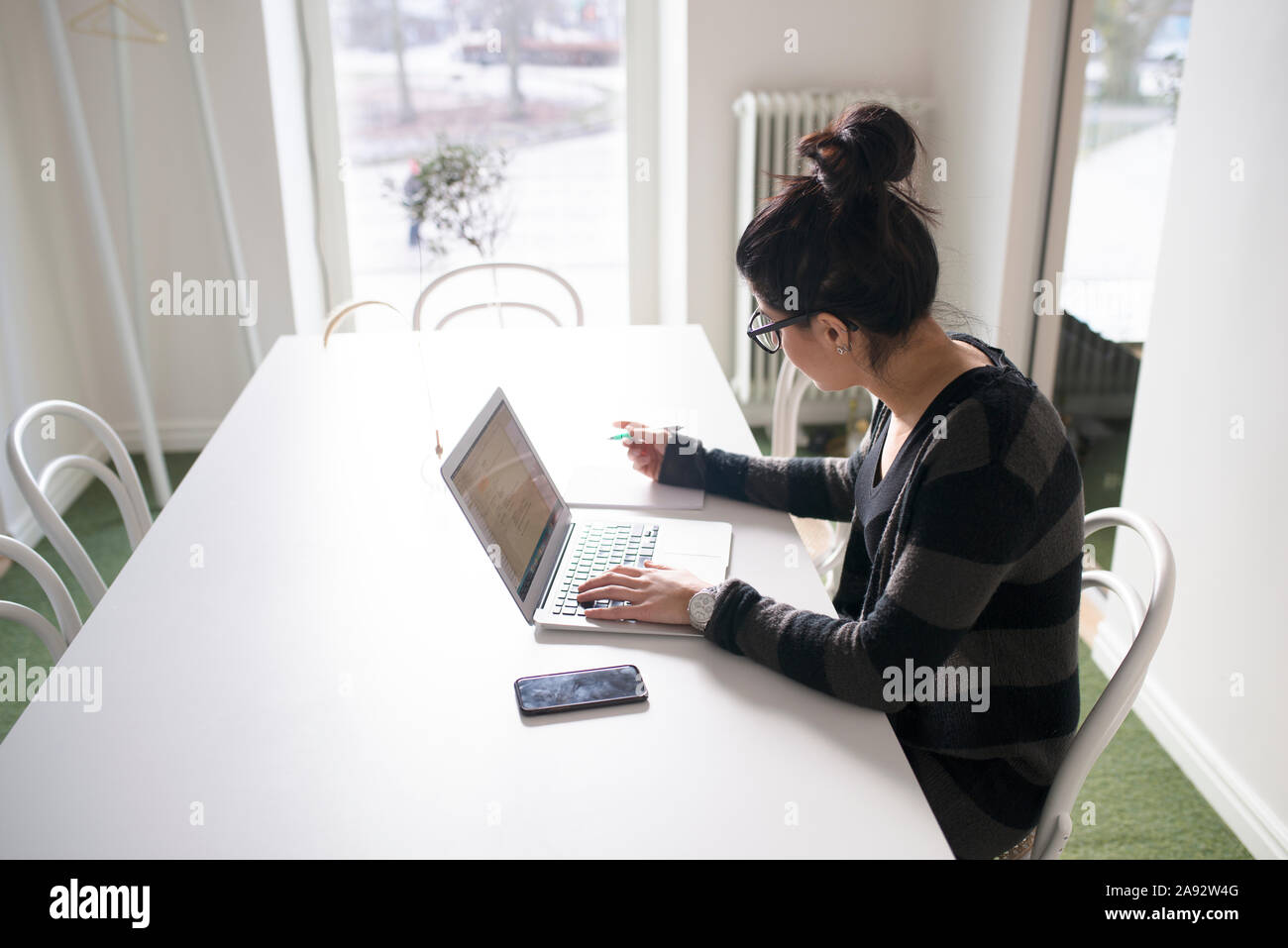 Mujer en Office mediante ordenador portátil Foto de stock