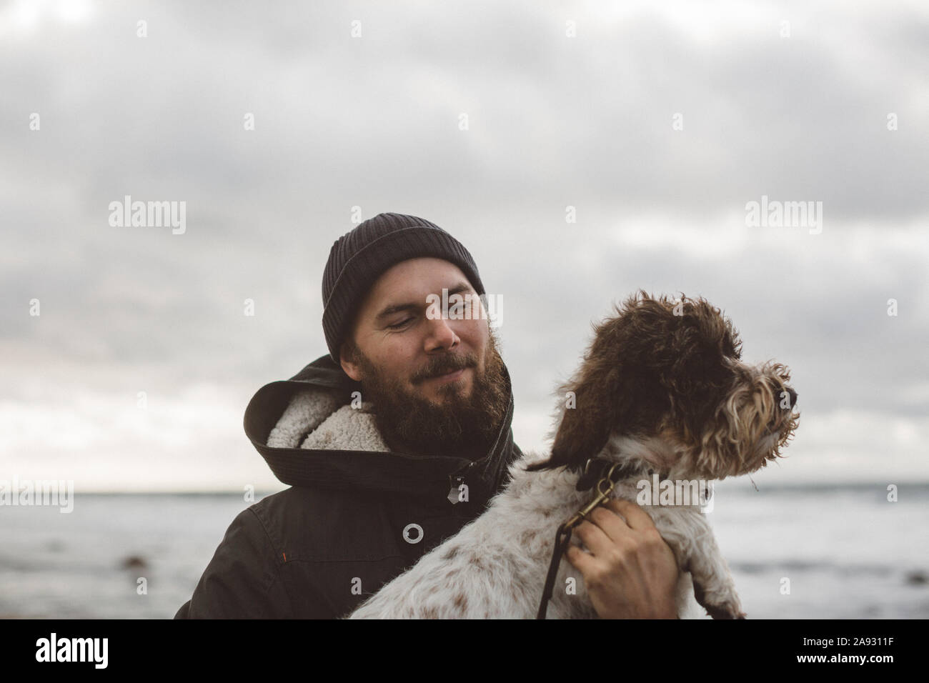 El hombre con el perro en el mar Foto de stock