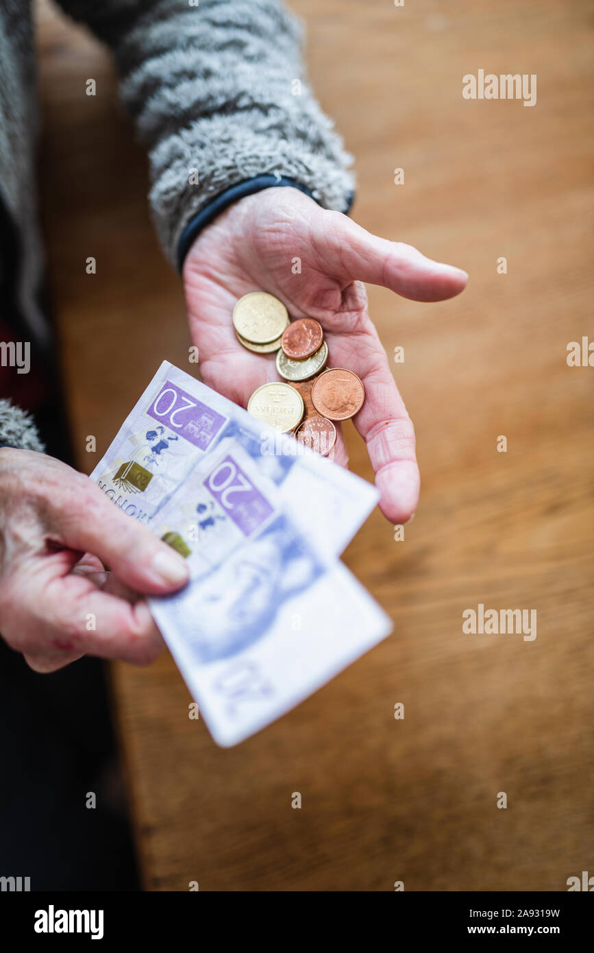 Manos sosteniendo los billetes y monedas Foto de stock