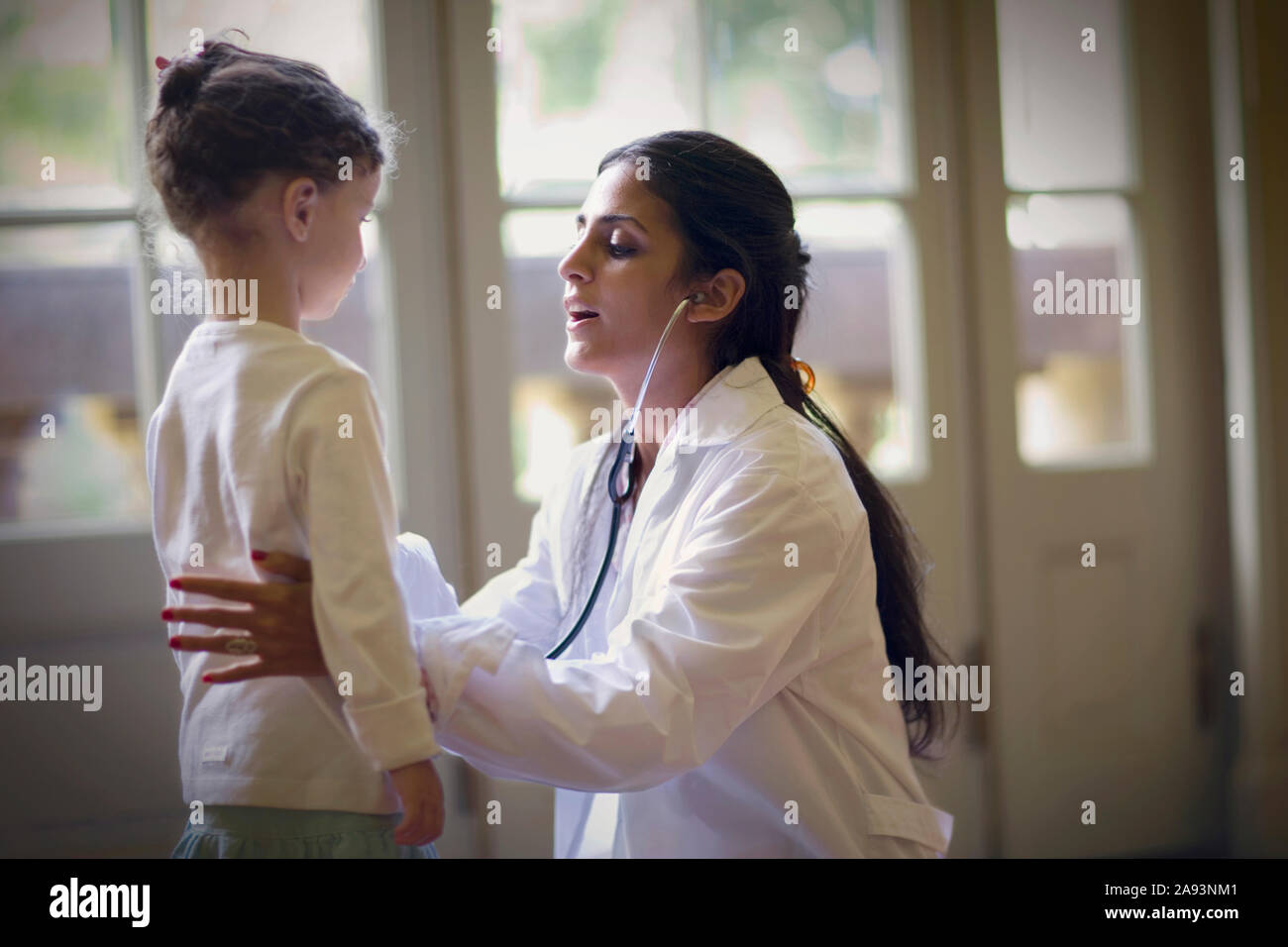 Vista de una señora médica que revisa a una niña pequeña Foto de stock