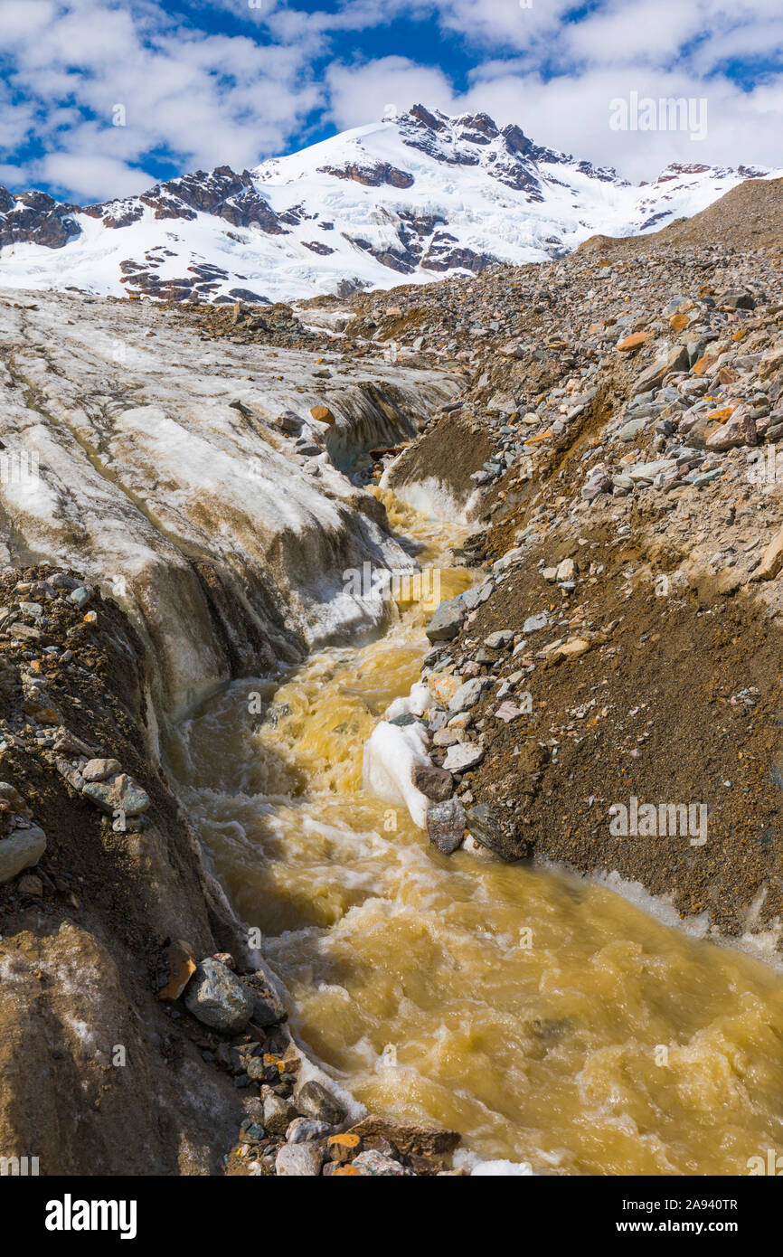 Un flujo de agua de deshielo fluye por el glaciar Castner con el Monte Silvertip elevándose en el fondo; Alaska, Estados Unidos de América Foto de stock