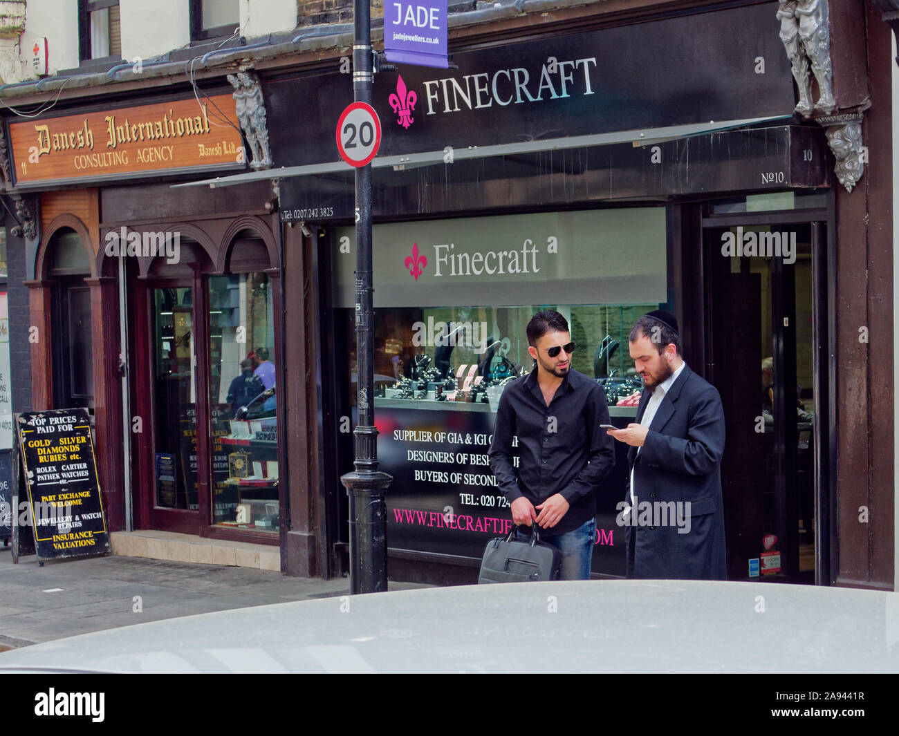 Los hombres hablar de negocios en la joyería Hatton Garden de Londres, en el barrio de pie en frente de una joyería. Un hombre vestido con kippah. Foto de stock