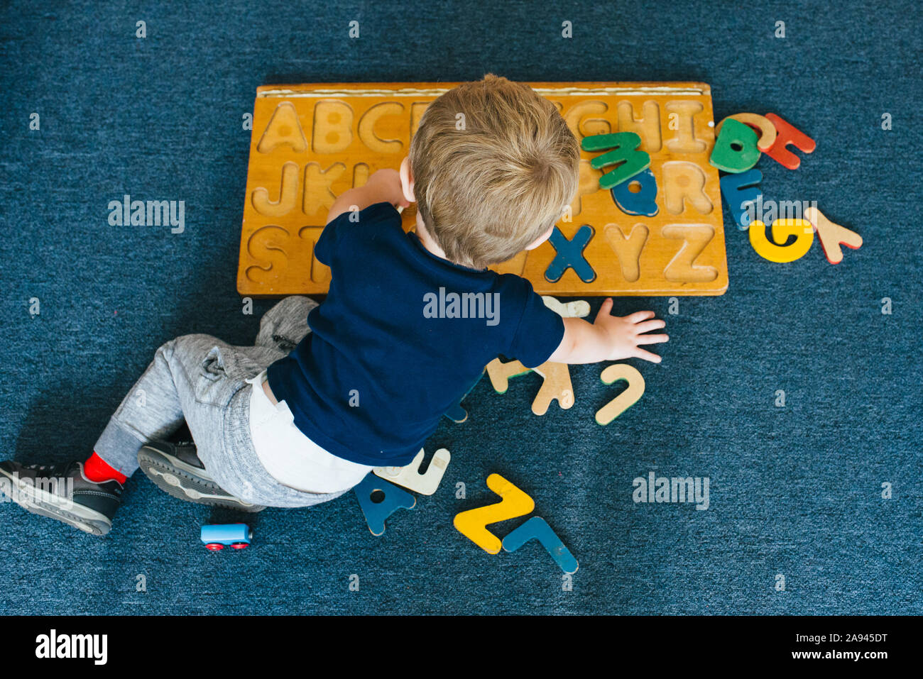 Un niño juega con un alfabeto rompecabezas. Foto de stock