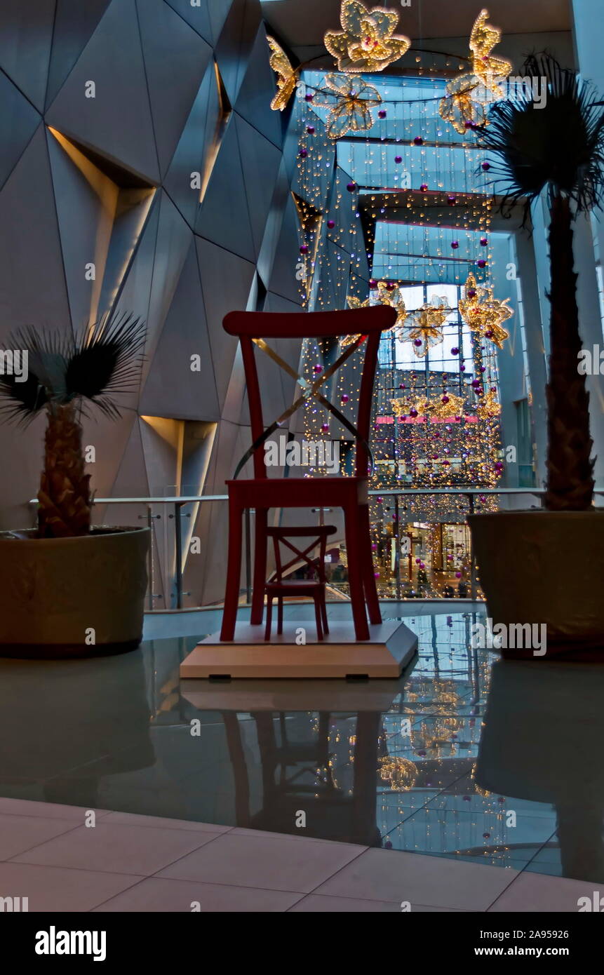 Ambiente festivo en un centro comercial creado por hermosos accesorios de iluminación colgado del techo con dos sillas de Santa Claus y la nieve Princesa Sofía, Bulgaria Foto de stock