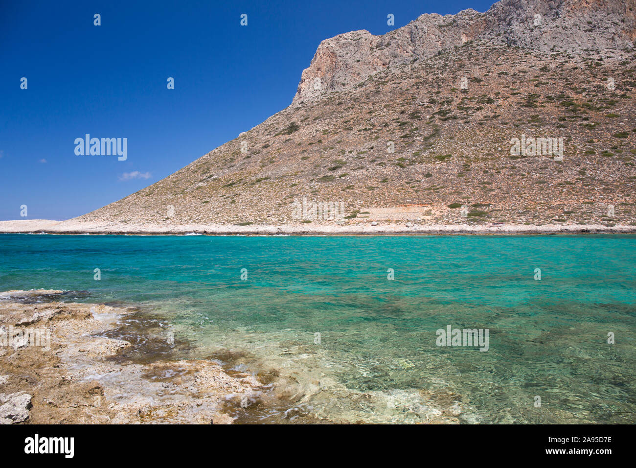 Stavros, Chania, Creta, Grecia. Vista a través de las aguas turquesas de la bahía de Traili a las escarpadas laderas de Vardies. Foto de stock
