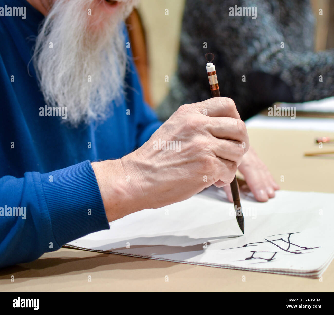 Maestro de caligrafía china dibujo jeroglífico con una brocha. Foto de stock