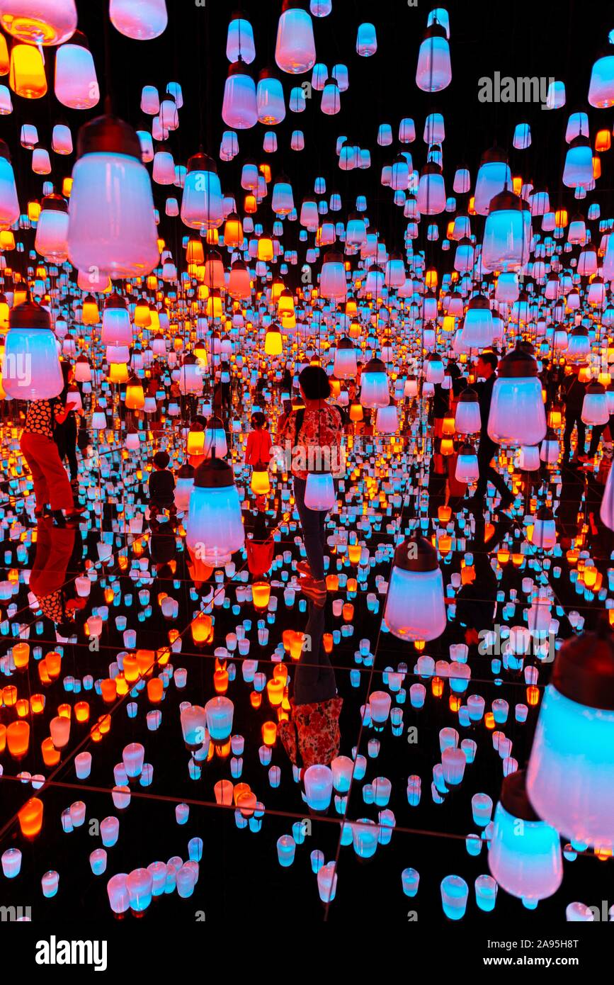 Los visitantes en el medio de una instalación de luz con lámparas iluminadas, una exposición en el Museo de Arte Digital, Epson Borderless TeamLab, Odaiba Foto de stock