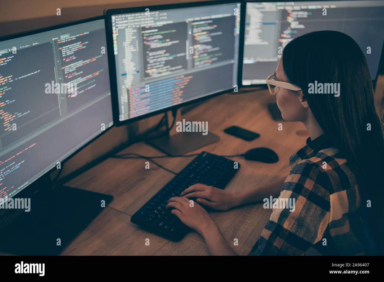 Vista posterior del administrador del sistema modificando el software de seguridad corporativa para evitar la empresa de ser atacado por los concursantes Foto de stock