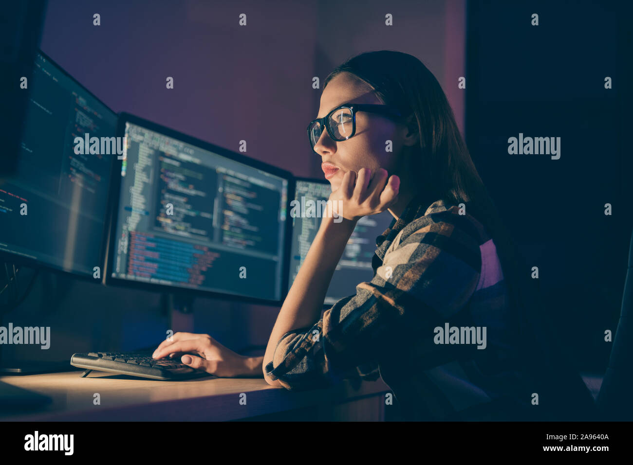 El perfil lateral foto de adivinar el pensamiento inteligente mujer que trabaja en el turno nocturno en lugar de su colega, el administrador del sistema Foto de stock