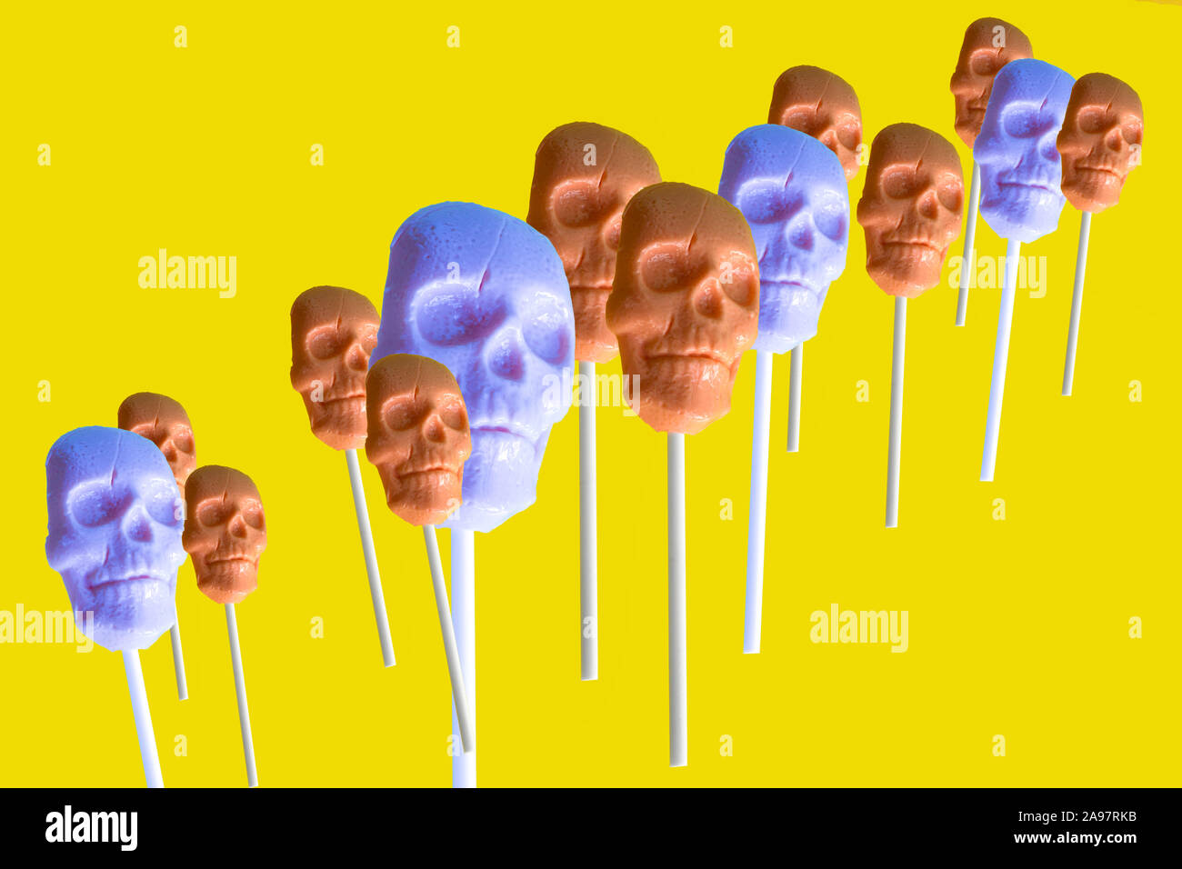 En un bastón de caramelo en la forma de una calavera sobre un fondo amarillo Foto de stock