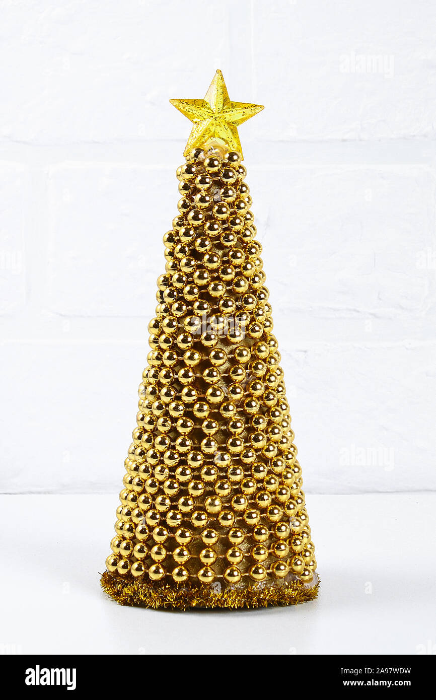 Árbol de Navidad de oro de bricolaje desde abalorios Garland. Guía sobre la  foto cómo hacer un árbol de Navidad decorativos de cartón, estrellas,  pegamento caliente y abalorios wit Fotografía de stock -