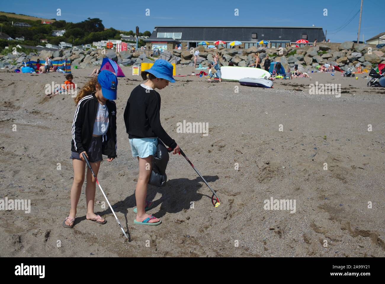 Los niños ayudan a limpiar la playa por el voluntariado para hacer cinco minutos de recogida de basura en Chalisborough. Devon UK Foto de stock