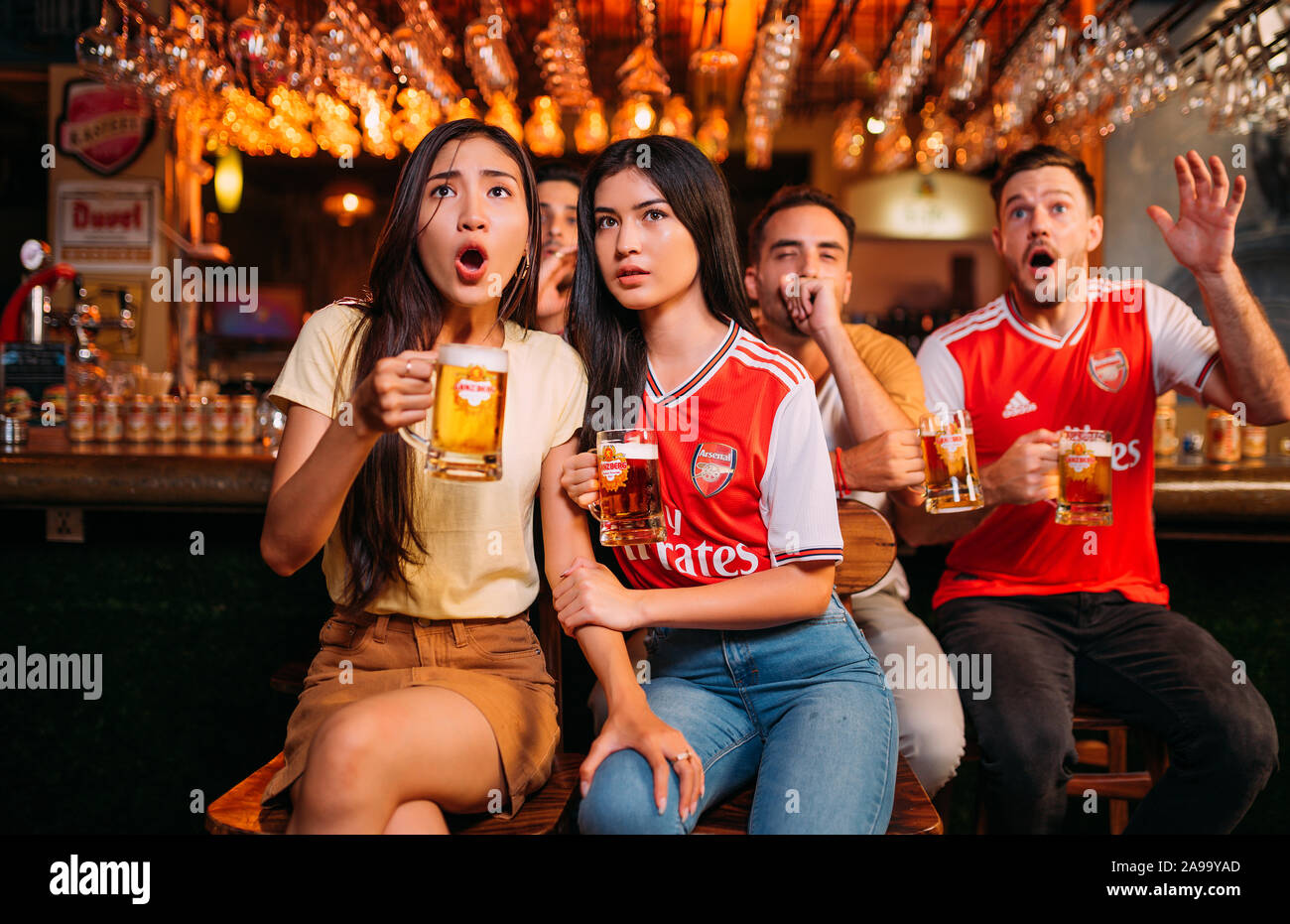 Aficionados al arsenal de la fiesta entusiasmados viendo el fútbol con Ganzberg Beer in el pub Foto de stock
