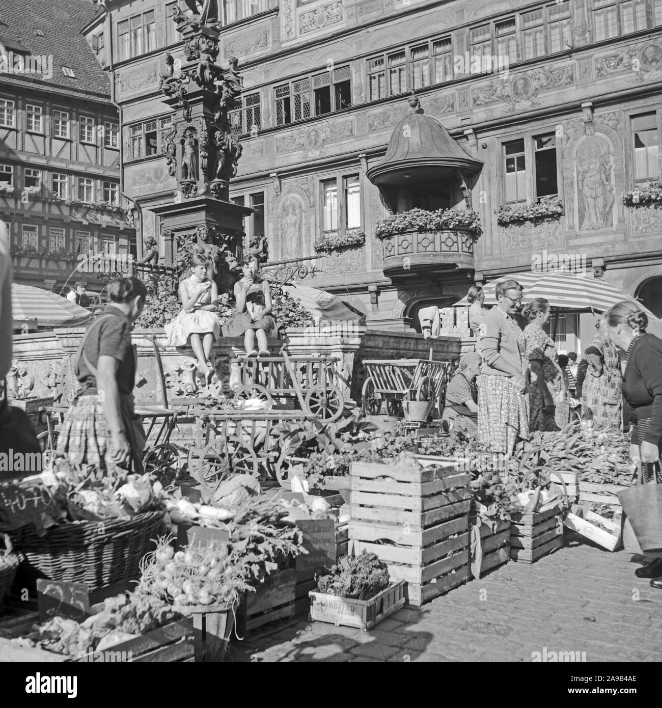 Stand de verduras en el mercado semanal de todo el Herkules Fountain, cerca del ayuntamiento de Heidelberg, Alemania 1956 Foto de stock