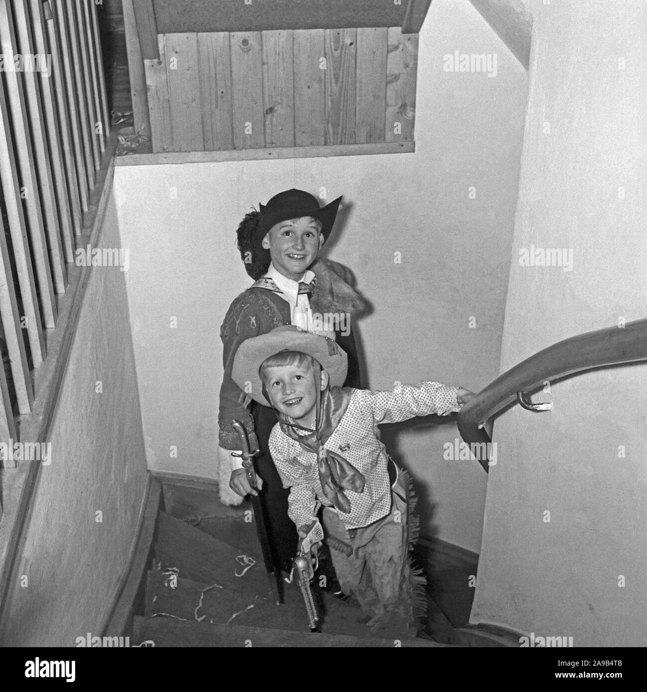 Dos muchachos vestidos como cowboy delirar por la casa durante el carnaval, Alemania 1959 Foto de stock