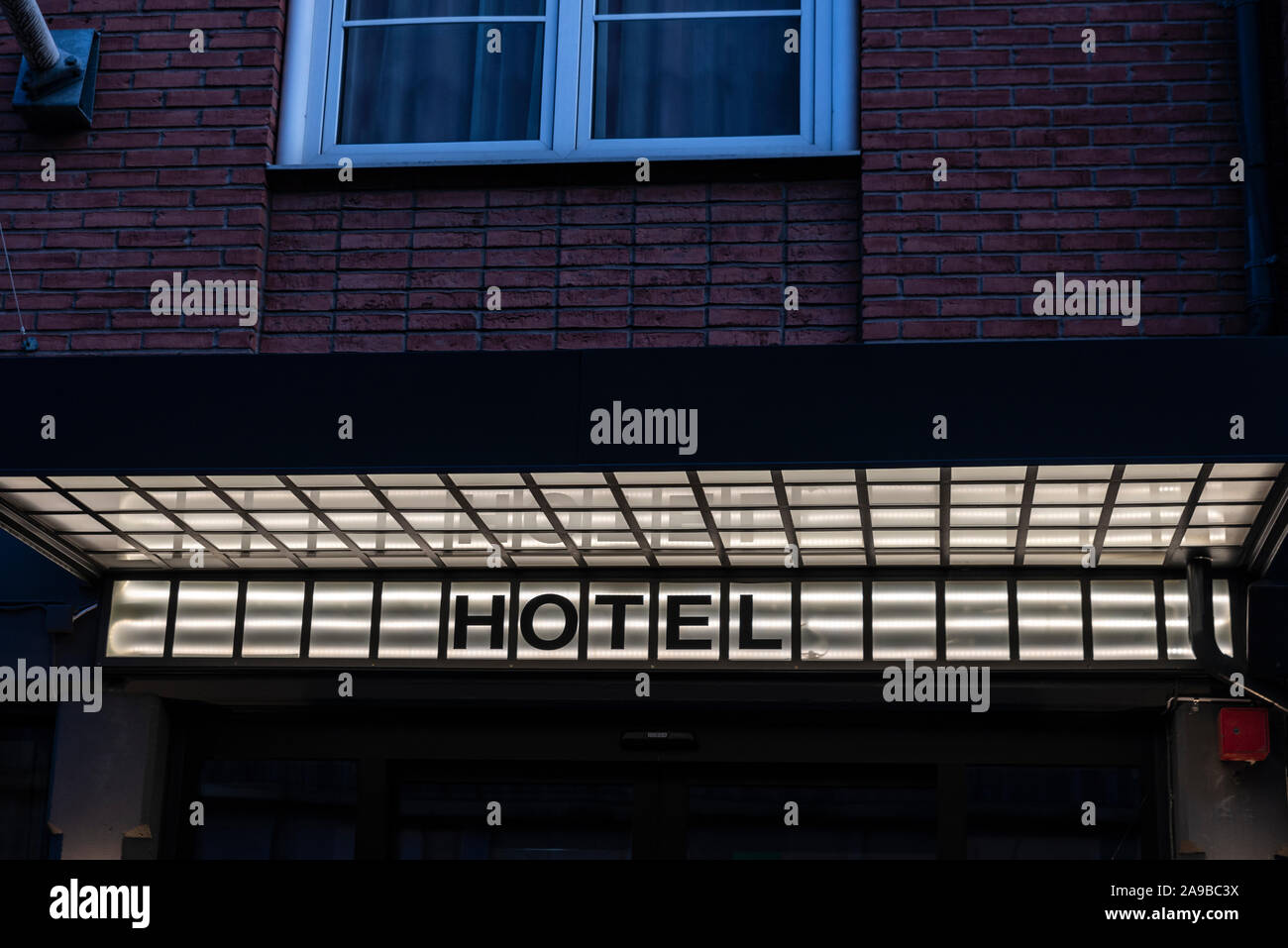 Hotel firmar iluminados durante la noche en un edificio en Malmo, Suecia Foto de stock