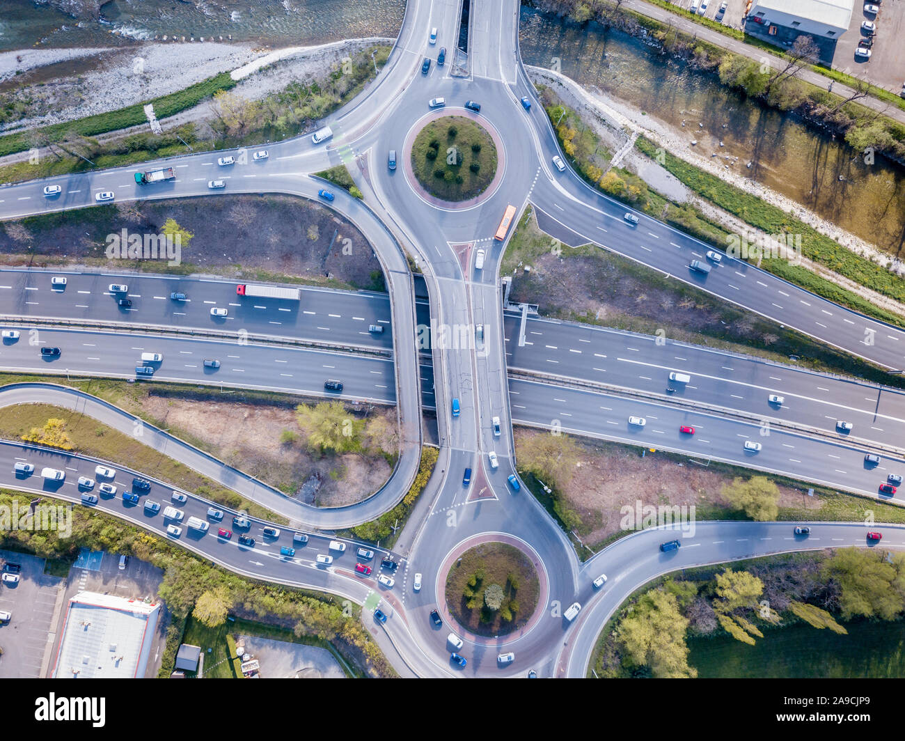 Highway interchange cruce con tráfico descendente Fotografía vista aérea de drone con vehículos circulando en autopista, rotonda y carriles de rampa, tra Foto de stock