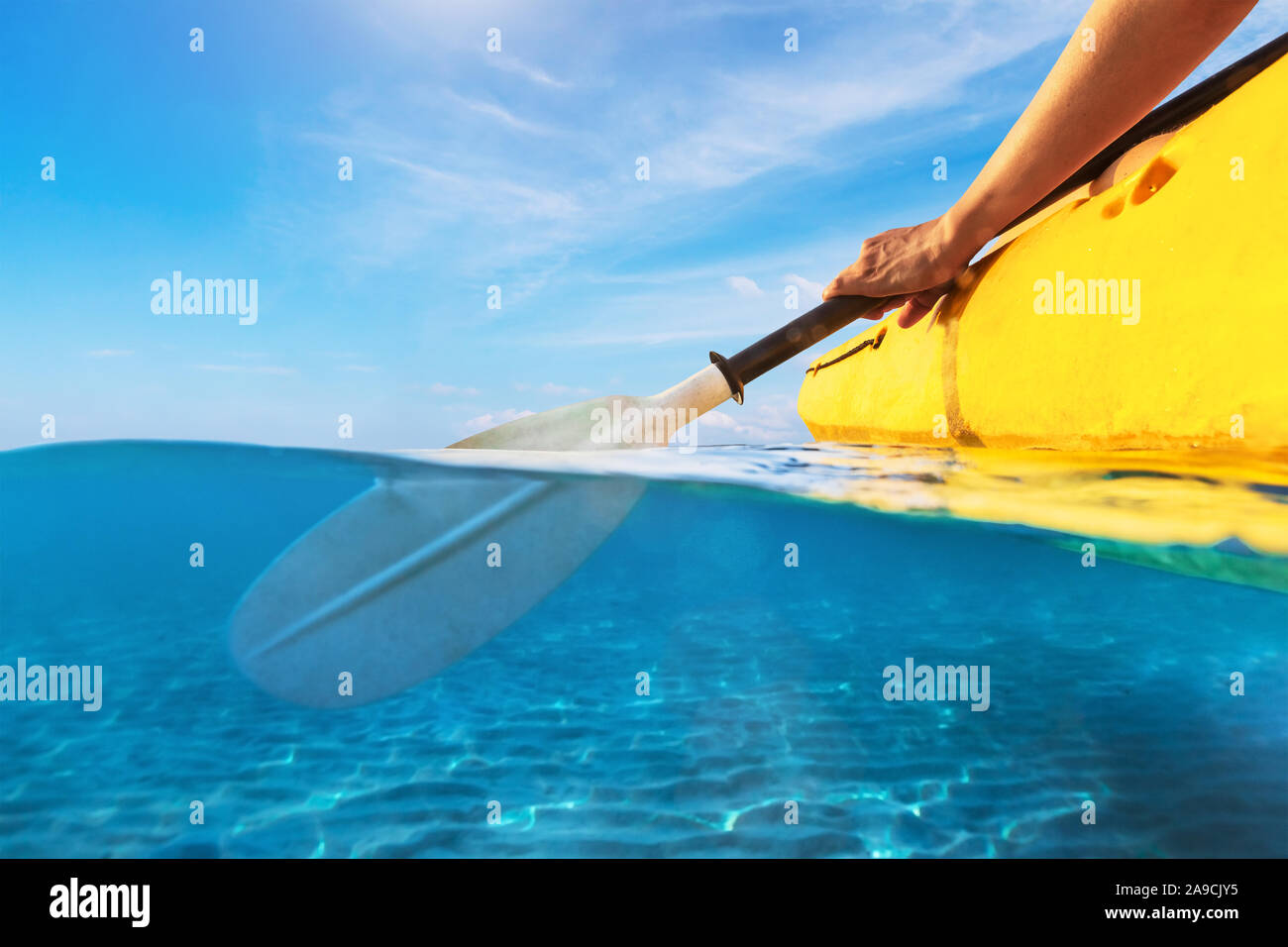 Vista dividida de persona kayak en mar azul transparente, agua y encima de la fotografía submarina de kayak y remar en verano cálido tropical desti viajes Foto de stock