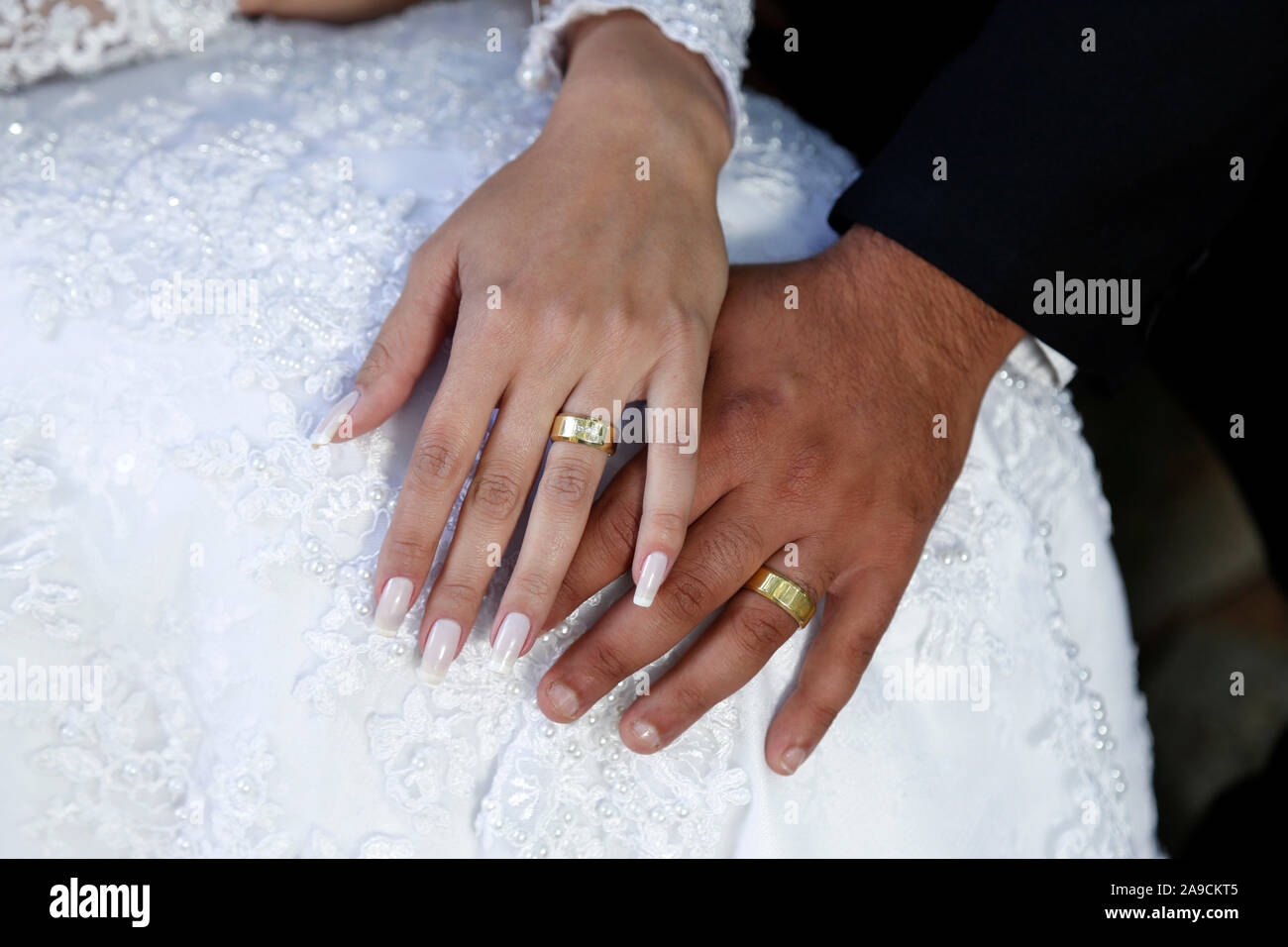 Manos unidas y anillos de boda, el detalle de las manos de la novia y el  novio vestidos de los anillos de boda, anillos de boda, joyas, unieron sus  manos Fotografía de