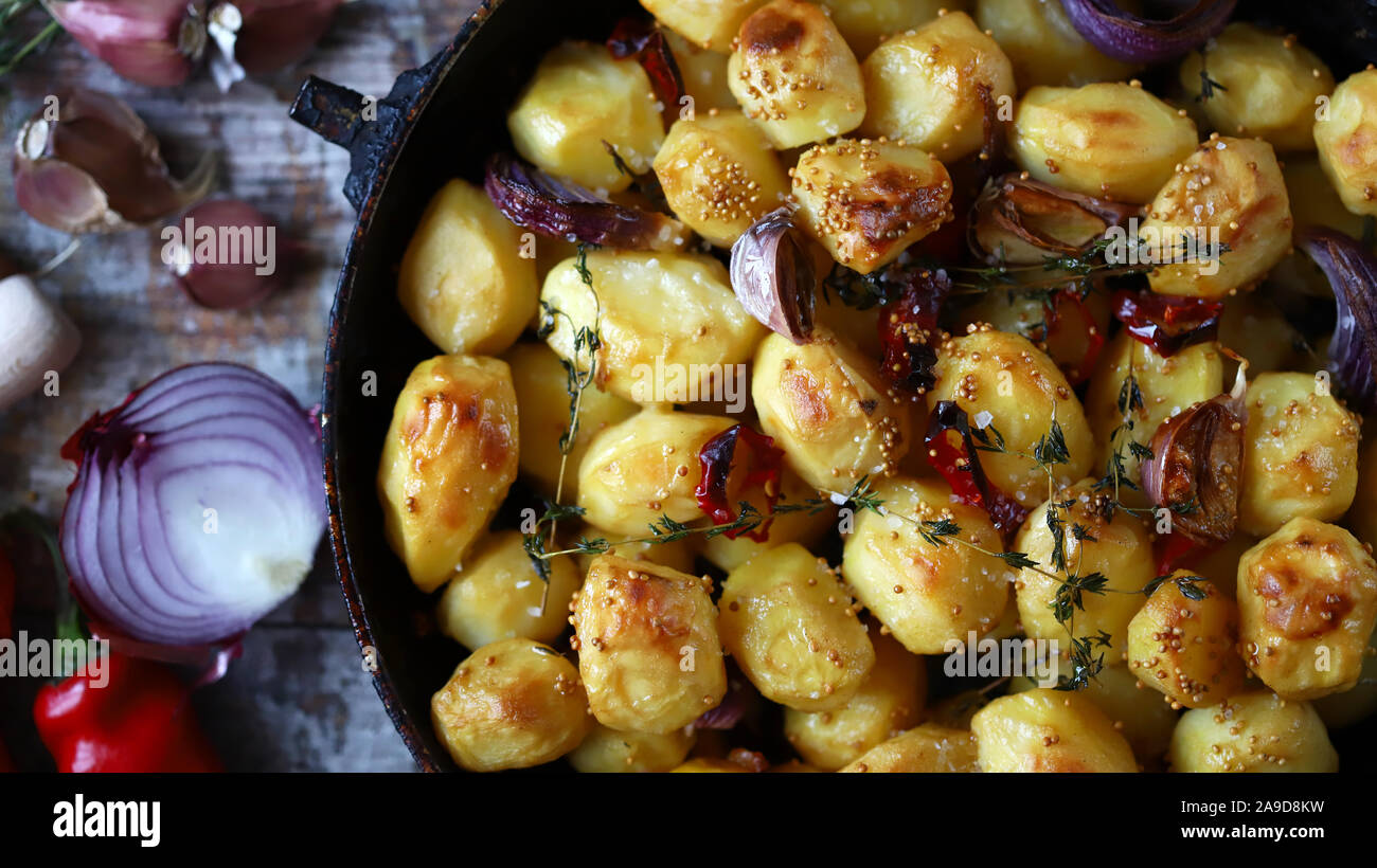 Apetitosos patatas horneadas enteras en una sartén. Patata rústica al horno  con ajo, hierbas y especias Fotografía de stock - Alamy