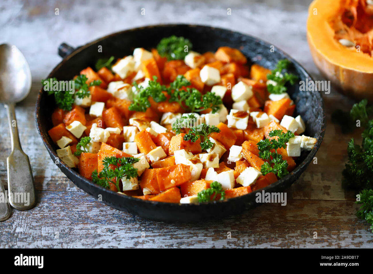 Ensalada con calabaza cocida y queso feta. Thanksgiving ensalada. Otoño ceto ensalada. Dieta ceto. El enfoque selectivo. Macro. Foto de stock