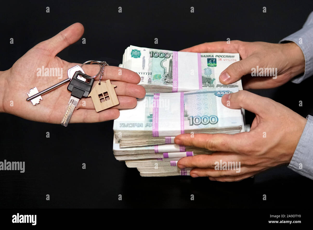 Billetes de rublos rusos y las llaves del apartamento en el cuadro negro. Venta inmobiliaria. El acuerdo para la venta de los apartamentos. Concepto real estate tra Foto de stock