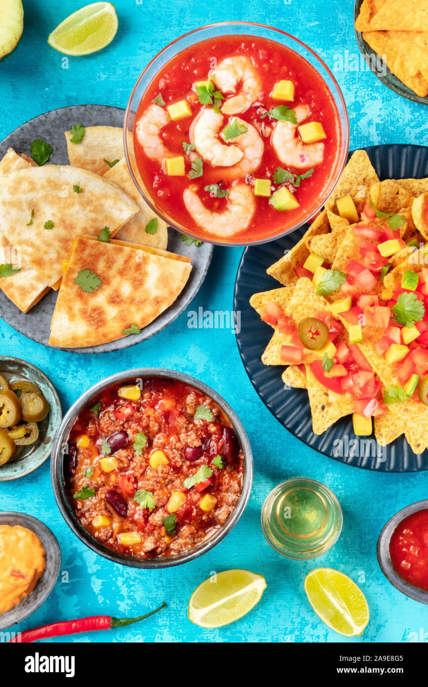 Comida mexicana, muchos platos de la cocina de México, lay flat top-down  shot sobre un fondo azul vibrante. Cóctel de Camarones, nachos, tequila,  chili con carne Fotografía de stock - Alamy