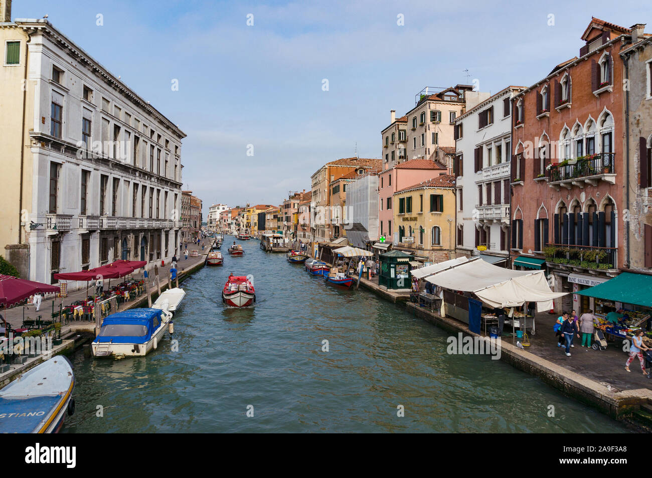 Venecia, Italia - 27 de septiembre, 2013: Vista sobre el Canal de Cannaregio, con barcos y mercado de frutas en el terraplén en la soleada mañana Foto de stock