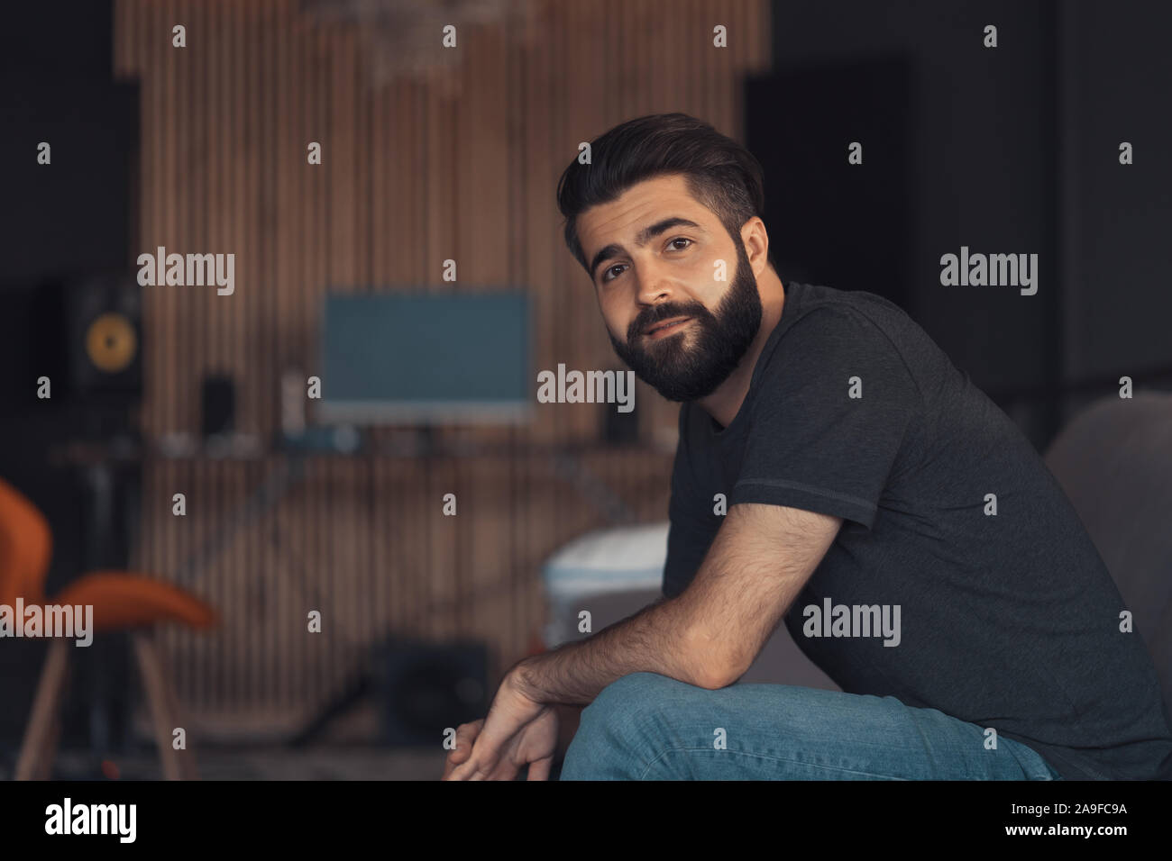 Joven chico atractivo relajante sentarse en un sofá en su oficina loft Foto de stock