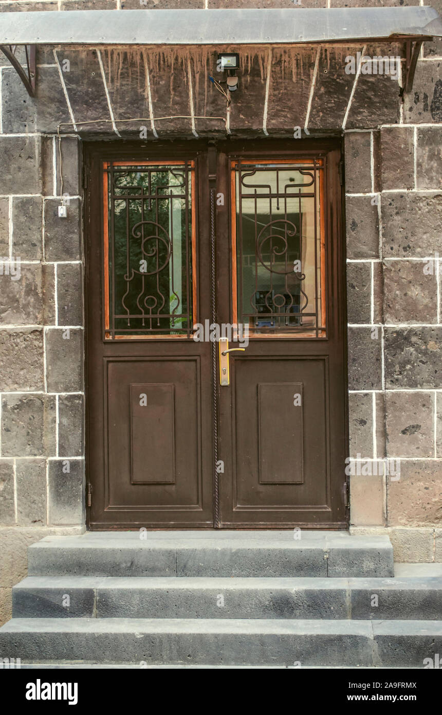 Una puerta doble de hierro marrón con ventanas cubiertas con rejas de hierro  forjado adornadas con una escalera bajo un dosel de hierro Fotografía de  stock - Alamy