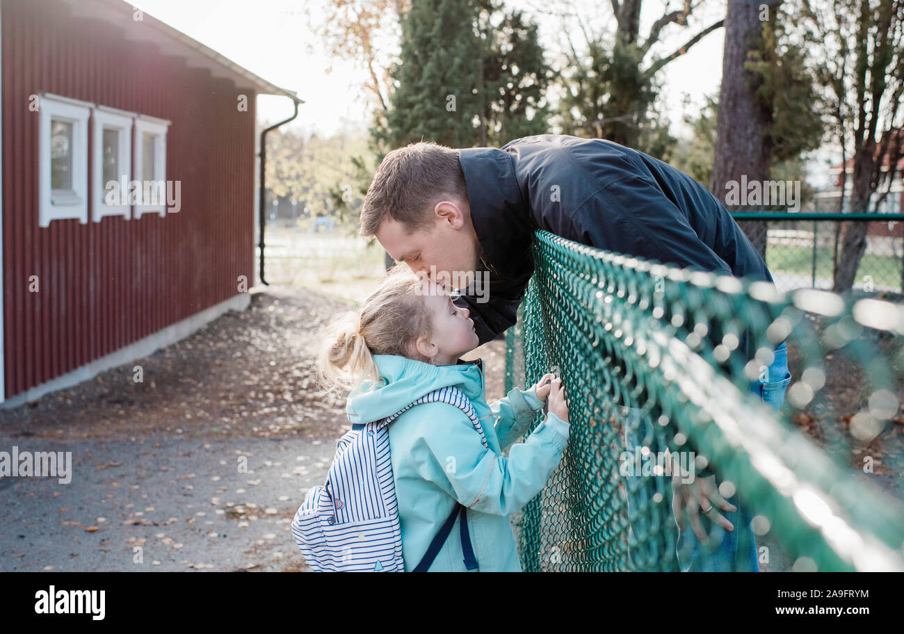 Padre besando a su hija en la escuela Adiós gate Foto de stock