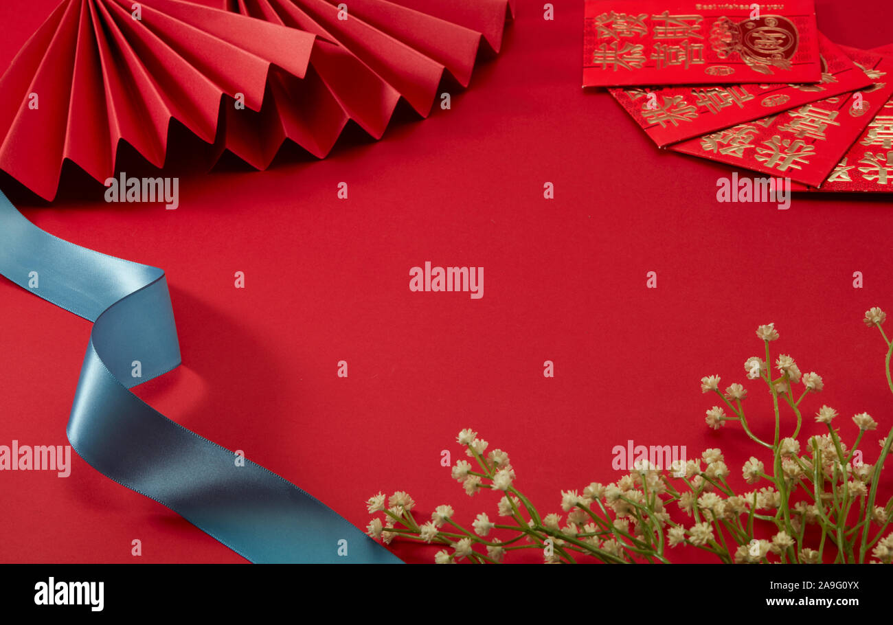 El fondo rojo del tema del Año Nuevo chino, con rojo ventilador plegable y lucky money, Florecilla y cinturón azul,:traducción puede ser la prosperidad con usted Foto de stock