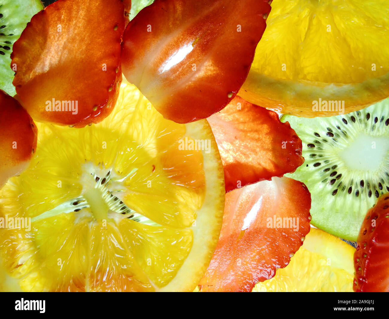 El mundo de color retroiluminado con rodajas de frutas frescas Foto de stock
