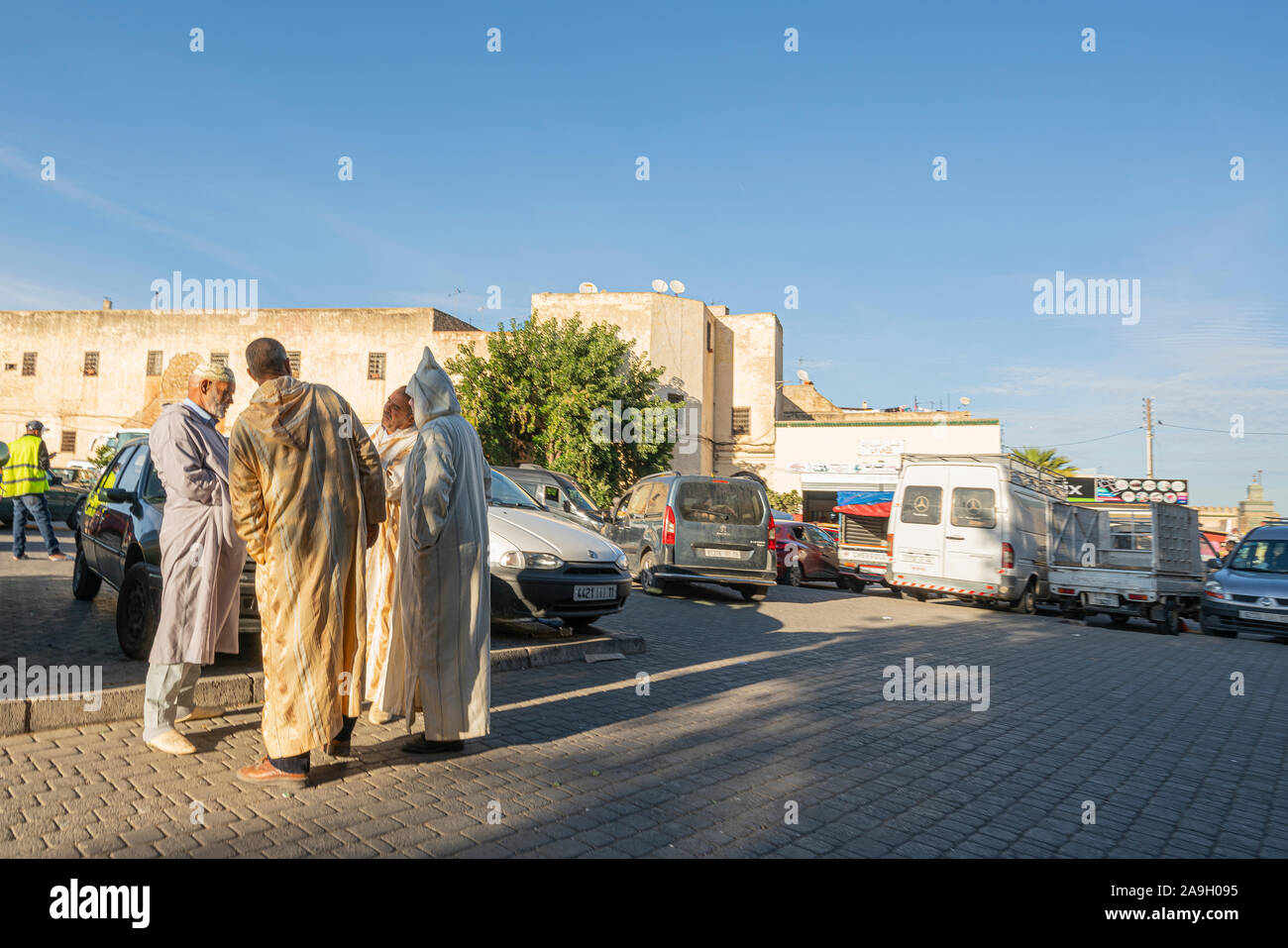 Fez, Marruecos. El 9 de noviembre de 2019. tres hombres en ropas tradicionales hablar sobre una calle Foto de stock