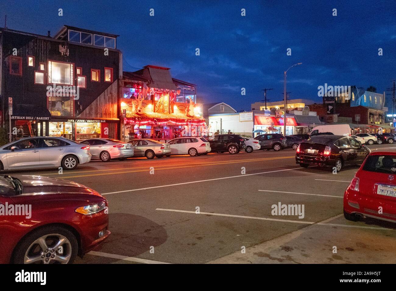Vista nocturna de la brillantemente iluminada tiendas y restaurantes a lo largo de Washington Blvd, una de las calles principales de Venecia, la ciudad de Los Angeles, California, 27 de octubre de 2019. () Foto de stock