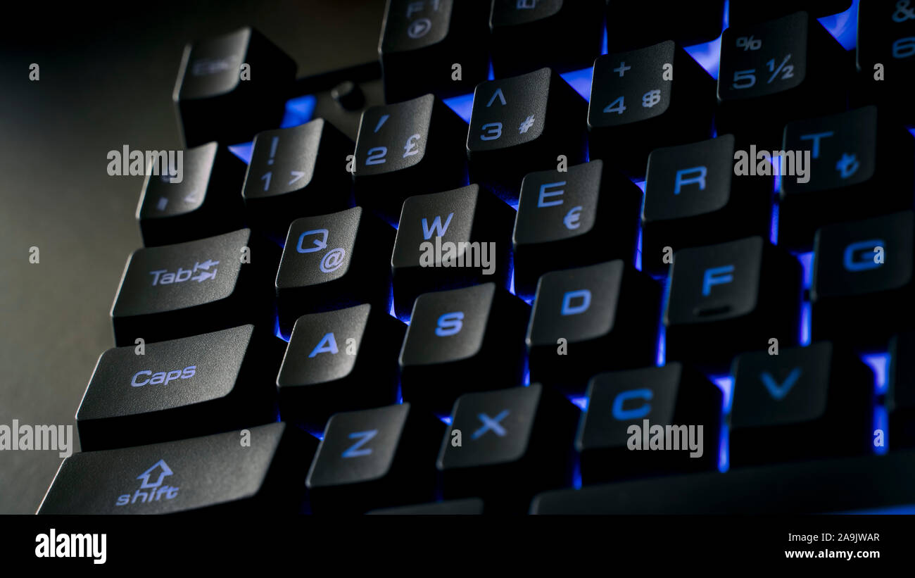 Primer plano de un teclado para juegos con luces LED azul Foto de stock