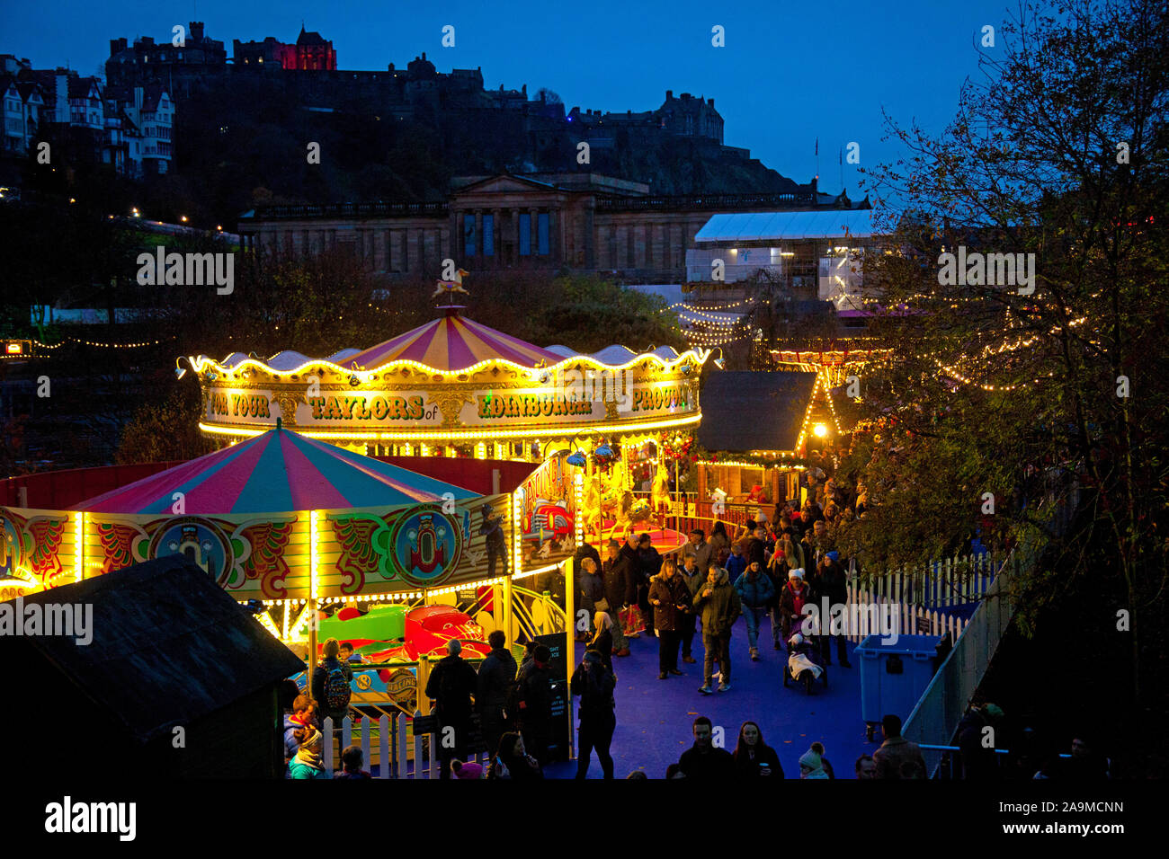 Los jardines de Princes Street, Edimburgo, Escocia, Reino Unido. 16 de noviembre de 2019. Feria de Navidad y el mercado se abre. Carrusel con el castillo de Edimburgo en el fondo. Foto de stock