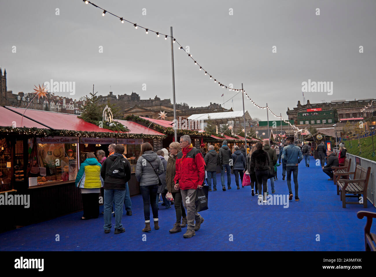 Los jardines de Princes Street, Edimburgo, Escocia, Reino Unido. 16 de noviembre de 2019. Mercado de Navidad y Feria abre hasta tarde. Molino de la gente alrededor de los establos en busca de regalos y obsequios. Foto de stock