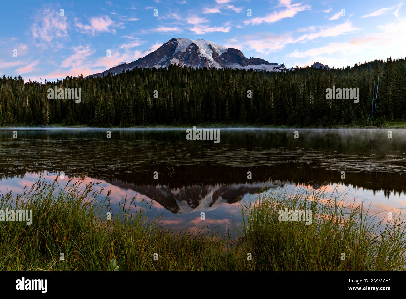 WA17292-00...WASHINGTON - El amanecer en la reflexión de los lagos con el Monte Rainer se refleja en las aguas tranquilas. El Parque Nacional Monte Rainier. Foto de stock
