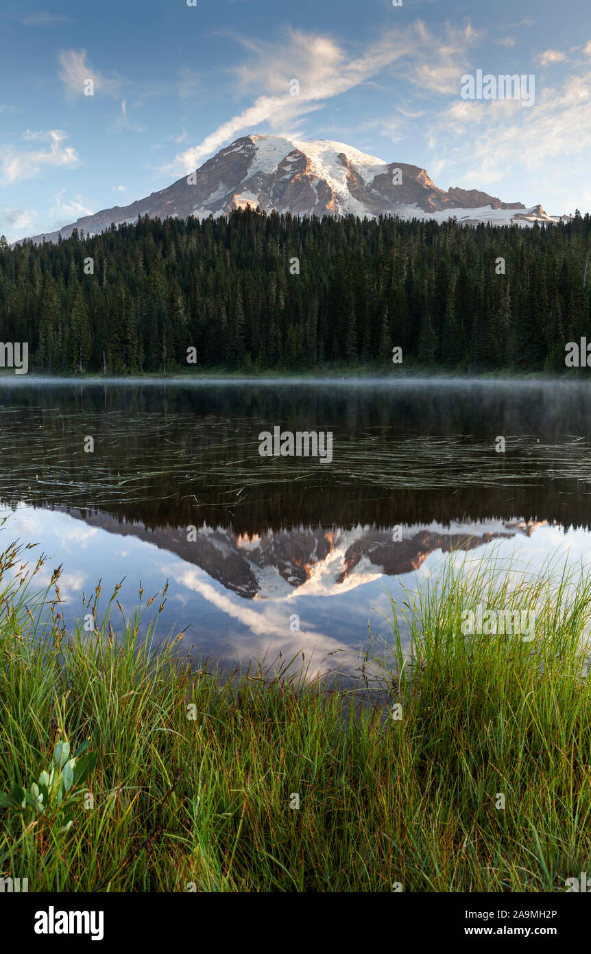 WA17293-00...WASHINGTON - El amanecer en la reflexión de los lagos con el Monte Rainier reflejado en las aguas tranquilas, el Parque Nacional Monte Rainier. Foto de stock