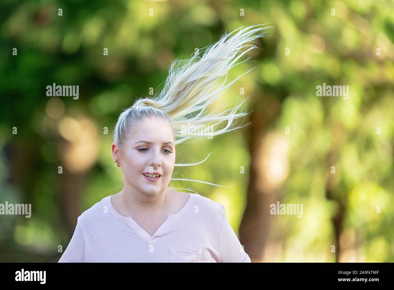 Cerca de la mujer correr y volar en el cabello suave y hermosa luz tarde antecedentes Foto de stock