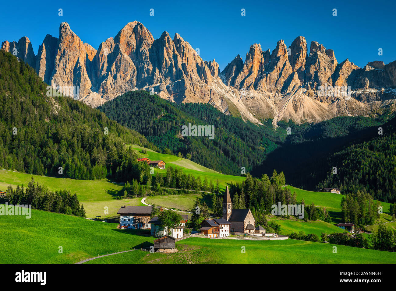 Pintoresco pueblo alpino con la iglesia y el paisaje de montaña. Populares de senderismo, Turismo y fotografía ubicación con paisajes increíbles en Val di Funes Foto de stock